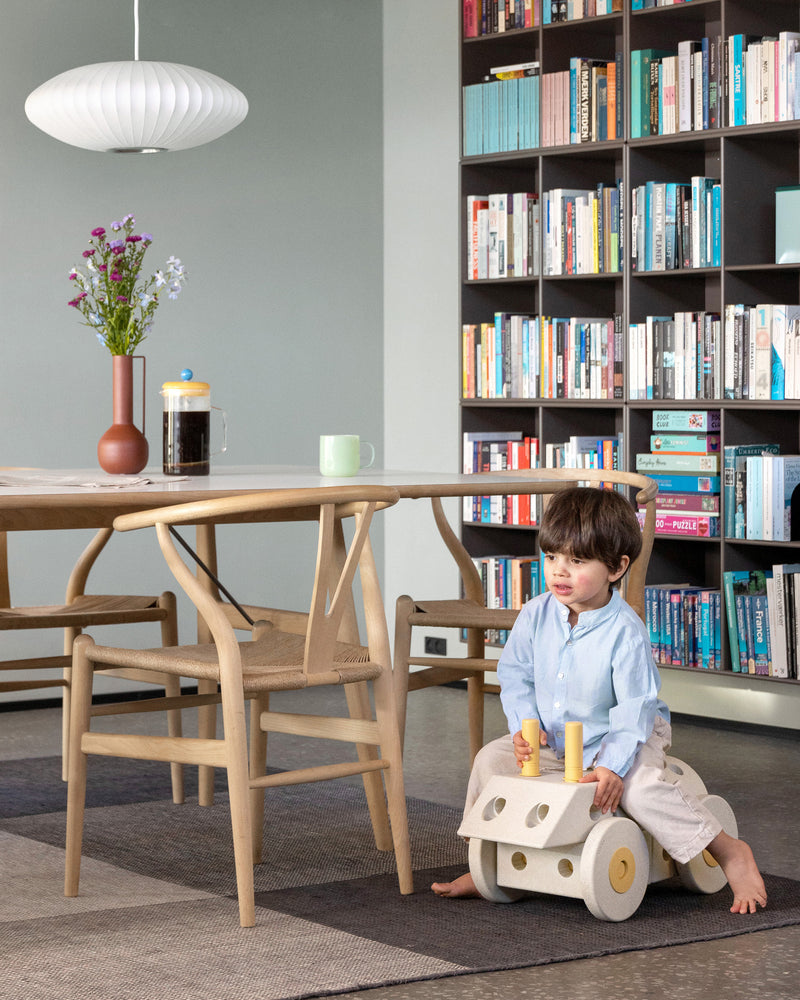 Toddler riding around on MODU ride on in the living room. Built from Dreamer Set in Sand Grey Honey Yellow.