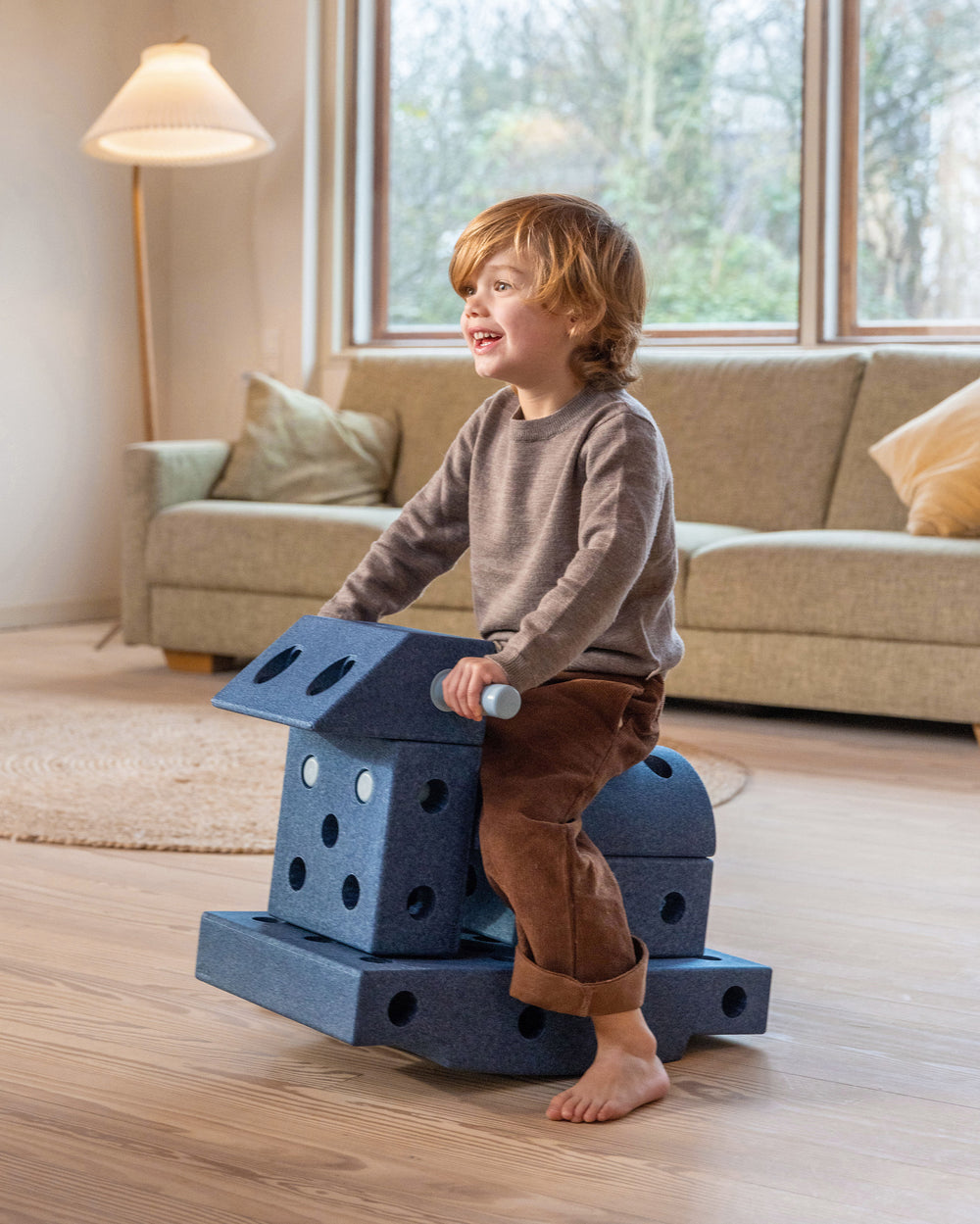Toddler riding a MODU rocker, a balance toy for toddlers and kids, built from an Explorer Set in Deep Blue Sky Blue.