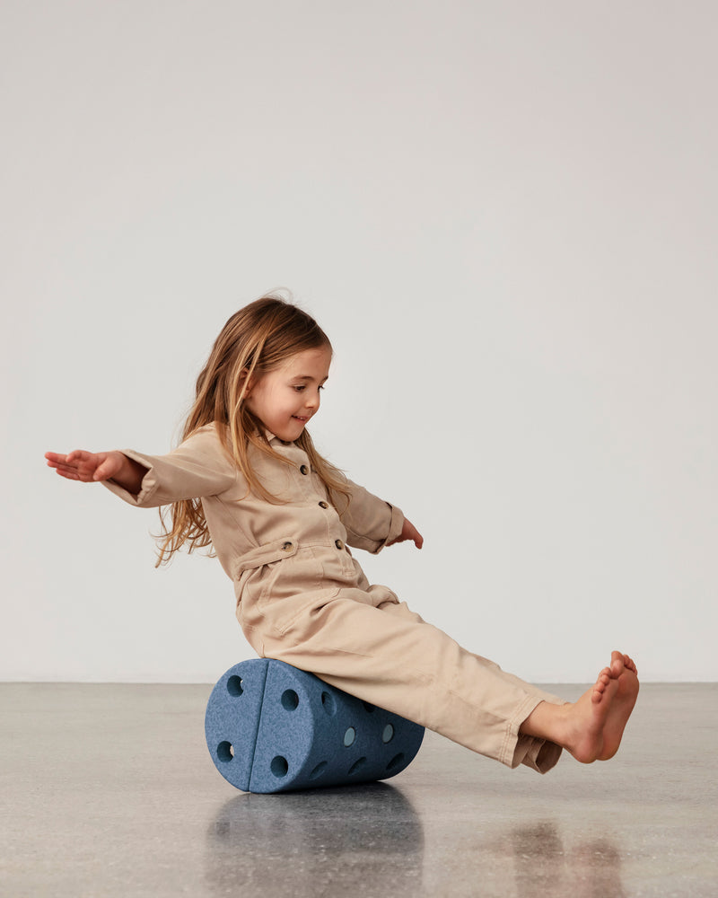 Toddler sitting on MODU Roller in Deep Blue Sky Blue, practicing balance.