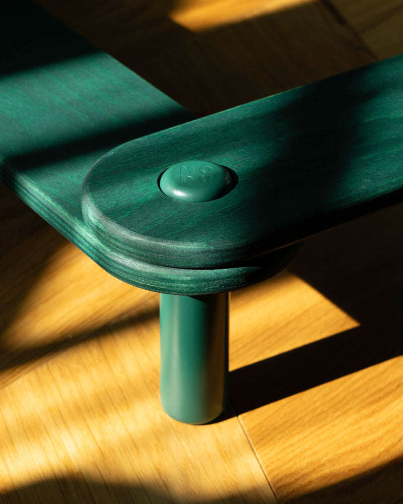 A close-up view of forest green MODU Balance Beams connected by forrest green connector peg.