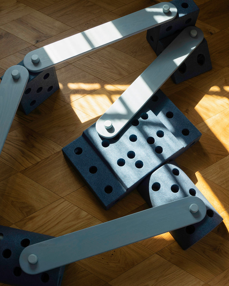 An overhead view of an intricate geometric balance track built from sky blue MODU Balance Beams and deep blue MODU foam blocks.