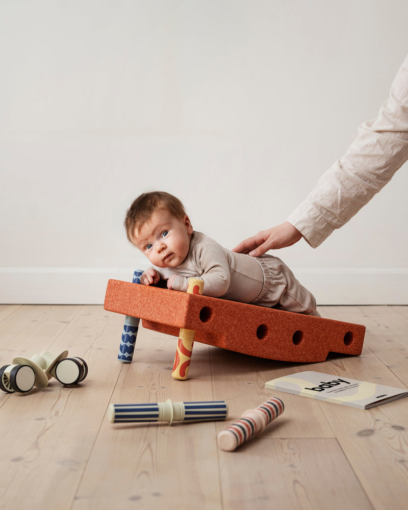 A baby practices tummy time on incline
built from the MODU Baby Activity Set.