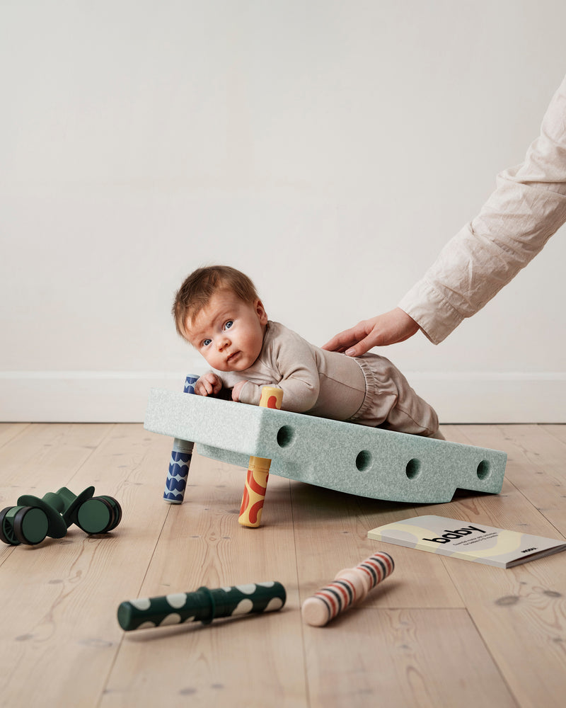 A baby practices tummy time on incline
built from the MODU Baby Activity Set.