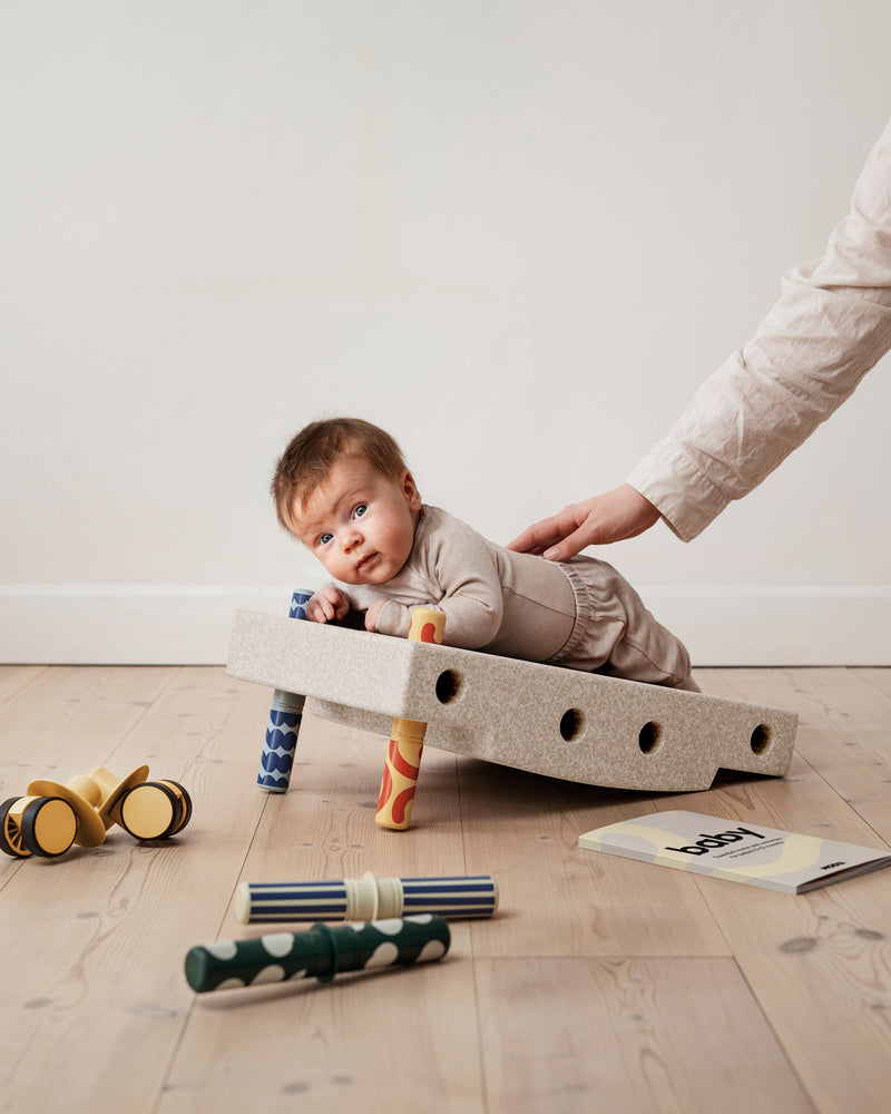 A baby practices tummy time on incline
built from the MODU Baby Activity Set.