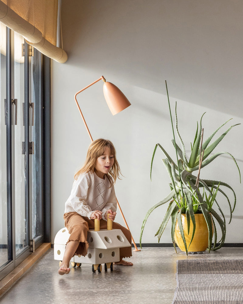 A child plays indoors riding a fast ride-on toy built from the MODU Explorer Set.