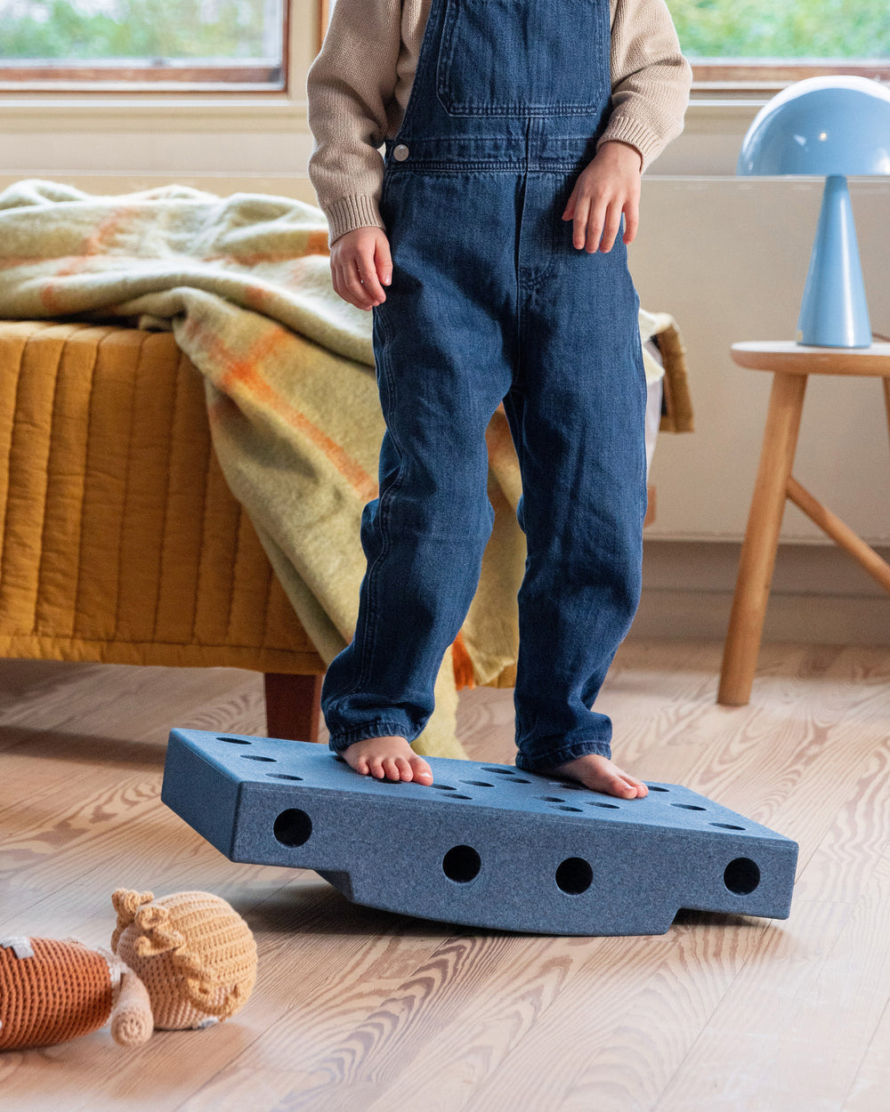 Toddler balancing on MODU base block. Life-sized building toy for open-ended active play.