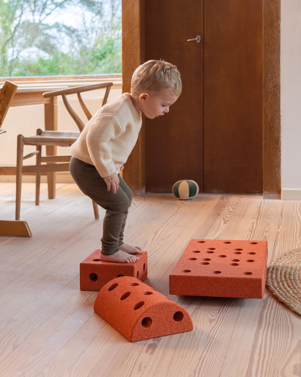 Toddler practicing motor skills on MODU obstacle course, built from Curiosity Set in Burnt Orange Dusty Green.