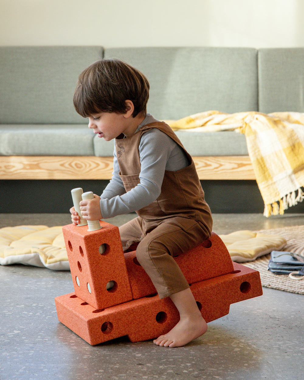 Young toddler riding MODU rocker, practicing balance skills. Built from Curiosity Set in Burnt Orange Dusty Green.