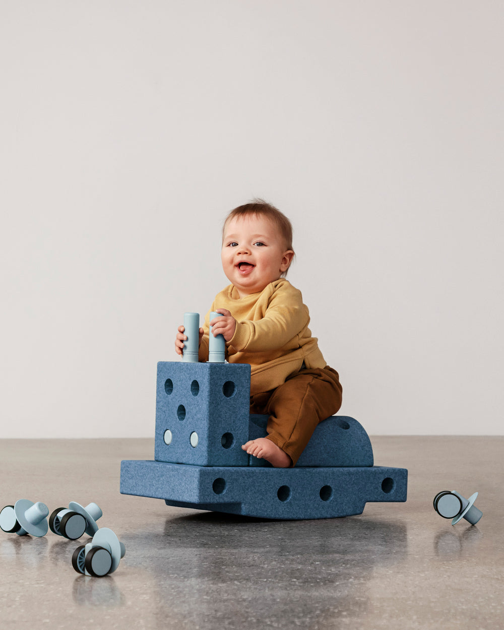 Baby having fun riding MODU rocker, practicing balance skills. Built from Curiosity Set in Deep Blue Sky Blue.