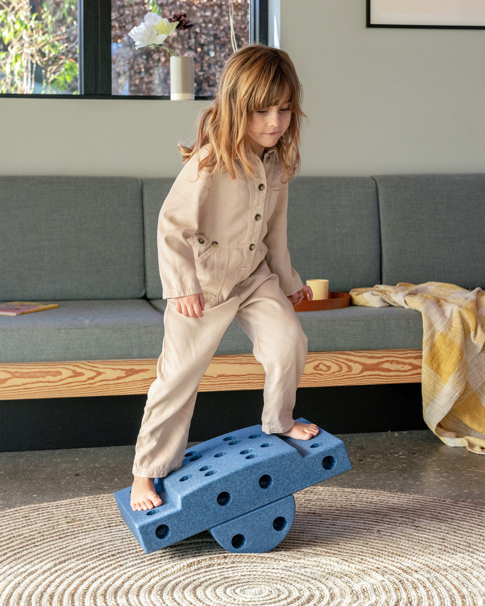 Toddler playing in the living room on a MODU balance board built from Curiosity Set in Deep Blue Sky Blue.