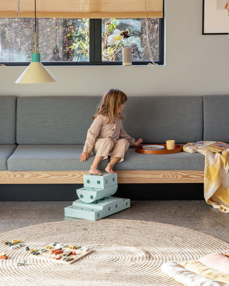 MODU-Treppe, ein Kindertritthocker, im Wohnzimmer platziert. Hergestellt aus dem Curiosity-Set in der Farbe Ocean Mint Forest Green.